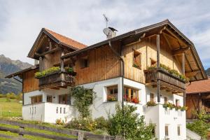 a wooden house with flowers on the windows at Inneroswalderhof in Anterselva di sotto