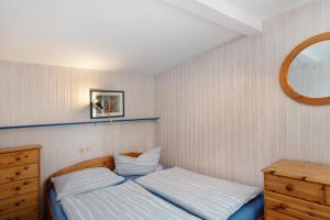 a bedroom with a bed and a dresser and a mirror at Möve Aba Bungalow 63 in Rerik