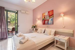 a bedroom with a large white bed and a window at Nontas Home 27 in Kalamitsi