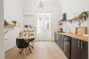 a kitchen with a wooden table and a small table with chairs at Piccolo Incanto Spa Palermo in Palermo