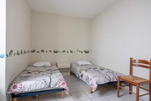 a bedroom with two beds and a chair at Maison proche océan - 6 pers in Bretignolles-sur-Mer