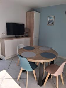 a table and chairs in a room with a tv at Maison proche océan - 6 pers in Bretignolles-sur-Mer