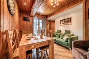 a dining room with a table and a couch at Appartement chalet - Le Vnipi in Abondance
