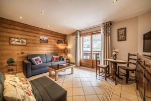 a living room with a couch and a table at Appartement chalet - Le Vnipi in Abondance