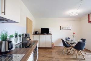 a kitchen with a counter and chairs and a table at Ferienwohnung Wiesenschneiders in Freiensteinau