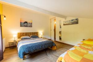 a bedroom with a bed with a blue comforter at Gite Senguinous 1 in Lesparre-Médoc +26 photos