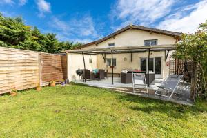 a backyard with a house with a fence at Gite Senguinous 1 in Lesparre-Médoc