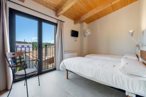 a bedroom with a bed and a balcony at Arassa casa rural in Rocafort de Queralt +27 photos