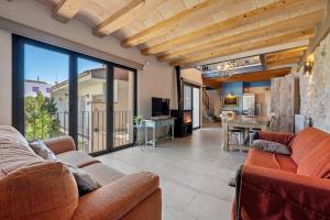 a living room with two couches and a kitchen at Arassa casa rural in Rocafort de Queralt