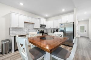 a kitchen with a wooden table and white cabinets at Marigold House in Foley