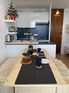 a kitchen with a wooden table with food on it at Brelin - Combes in Les Menuires +2 photos
