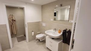 a bathroom with a sink and a toilet and a mirror at Ferienwohnung Burgstraße in Fuldatal