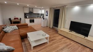 a living room with a couch and a flat screen tv at Ferienwohnung Burgstraße in Fuldatal
