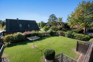 a garden with a large lawn with a house at Haus am Hemm in Meldorf