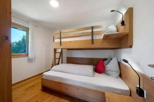 a small bedroom with a bunk bed and a window at Tholerhof in Schenna