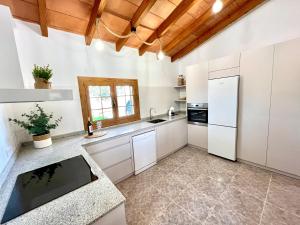a kitchen with white appliances and a wooden ceiling at Vinyes Can Grau in Sencelles