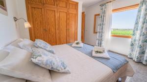 a bedroom with a bed with pillows and a window at Vinyes Can Grau in Sencelles
