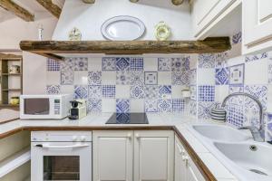 a kitchen with blue and white tiles on the wall at Can Roca in Montiró +29 photos