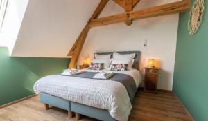 a bedroom with a large bed in the attic at Gîte La voisine in Venteuil