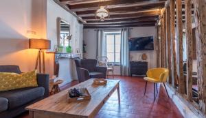 a living room with a couch and a table at Gîte La voisine in Venteuil