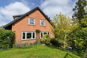 a red brick house with two windows and a yard at Ferienwohnung Flensburg Mürwik in Flensburg