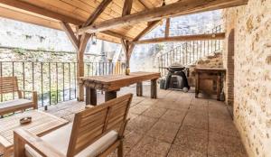 a patio with a wooden table and a grill at Gîte La voisine in Venteuil