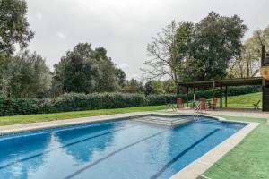 a swimming pool with chairs and a gazebo at Habitacions Mas Fuselles in Girona