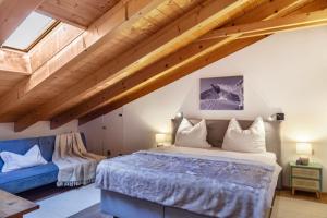a bedroom with a large bed and a blue couch at Ferienwohnung siebzehn35 in Garmisch-Partenkirchen