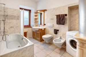 a bathroom with a tub and a toilet and a sink at Premesan 5 in Bormio