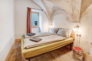 a bedroom with a large bed with a stone wall at Premesan 5 in Bormio