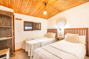 two beds in a room with wooden ceilings at La Caseta De Sant Grau in Navés +35 photos