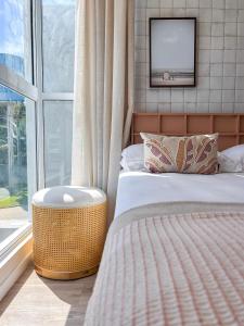 a bedroom with a bed and a tv on a wall at Casa Verde Mar Naluum in Passo de Camarajibe
