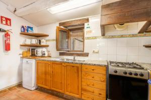a kitchen with a sink and a stove top oven at La Caseta De Sant Grau in Navés