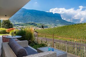 a patio with a table and chairs and a mountain at Landhaus Antonius Eppan in Appiano sulla Strada del Vino