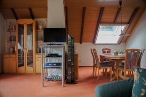 a living room with a tv and a table with chairs at Rauber Marie Theres in Abentheuer