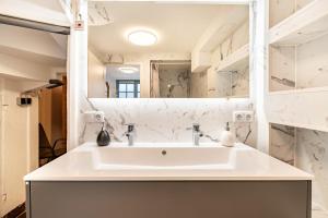 a bathroom with a white sink and a mirror at Ferienhaus bei Reichsburg Cochem in Cochem +30 photos
