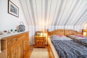 a bedroom with a wooden bed and a dresser and a bed sidx sidx sidx at Ferienwohnungen in Starsow in Mirow