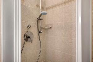 a shower with a shower head in a bathroom at Appartamento Piazza Bertamino in Bonassola +28 photos