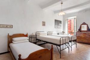 a bedroom with four beds and a dresser in it at Appartamento Piazza Bertamino in Bonassola