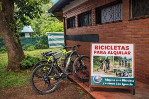 a bike parked next to a sign next to a building at Madre America Hotel & Hostel in San Ignacio