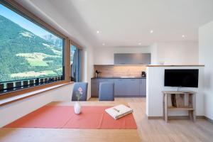 a kitchen and living room with a large window at Tholerhof in Schenna