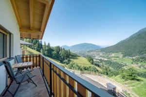 a balcony with a table and chairs and mountains at Tholerhof in Schenna