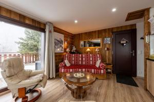 a living room with a couch and a table at Chalet d'Aillon in Aillon-le-Jeune
