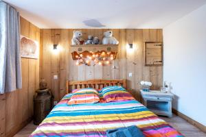 a bedroom with a bed with a wooden wall at Chalet d'Aillon in Aillon-le-Jeune