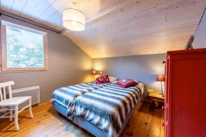 a bedroom with a bed and a wooden ceiling at Chalet du Fey in Valmorel