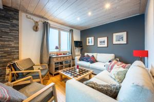 a living room with a couch and a table at Chalet du Fey in Valmorel
