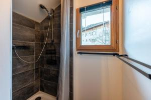 a bathroom with a shower and a window at Chalet du Fey in Valmorel +20 photos