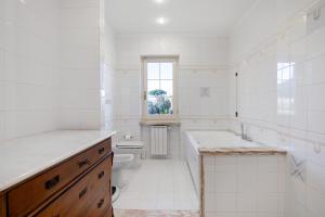 a white bathroom with a toilet and a sink at Villa Lucia in Ameglia +28 photos