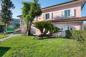 a house with two palm trees in front of it at Villa Lucia in Ameglia