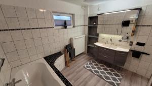 a bathroom with a tub and a sink at Ferienwohnung Friedhoff, 80qm in Schmallenberg +20 photos